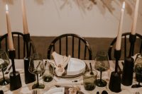 28 a stylish modern winter wedding tablescape with black candleholders and cutlery, grey glasses, grey and white plates and cool textural linens