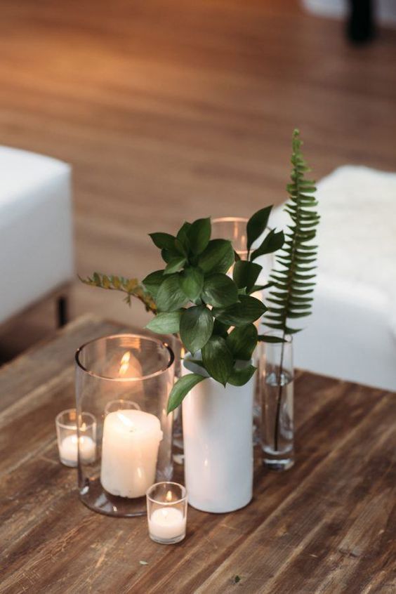 modern winter wedding decor of a white and clear vases, some greenery and candles is a lovely idea, and it can be your centerpiece