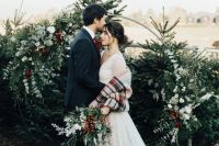 35 Christmas trees plus a gorgeous round wedding arch with greenery, white and burgundy blooms are amazing as a backdrop for a Christmas wedding