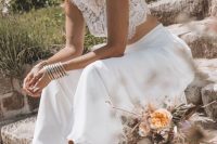 a boho western bridal look with a lace crop top, a plain midi skirt, cowboy boots and a nuetral hat decorated with dried grass