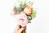 a bright wedding bouquet of peachy and pink blooms, greenery and a succulent is a cool solution for a summer wedding