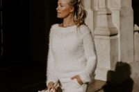 a cozy white cardigan with pearl buttons, white trousers and a chunky chain for a modern and casual bridal look