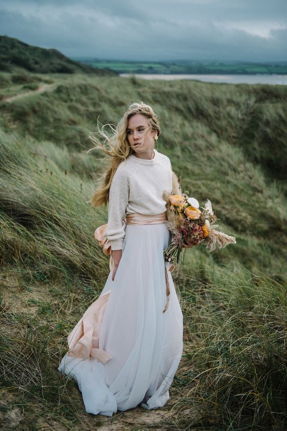 a delicate and casual winter bridal look with a neutral pearly sweater, a neutral A-line maxi skirt and a pink silk sash