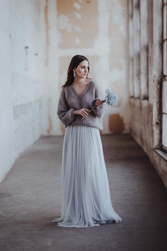 a dreamy chic and casual bridal look with a grey V-neckline oversized sweater, a blue tulle maxi, statement earrings and a blue hydrangea stem