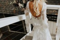 a girlish boho bridal look with a boho lace mermaid wedding dress with a cutout back and bell sleeves, a creamy hat with pastel blooms