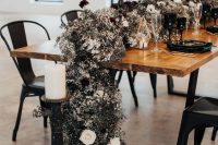 a jaw-dropping black and white wedding table runner of black and white blooms, fresh and dried ones, and black and white candles of various shapes
