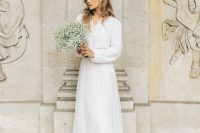 a lovely elegant casual bridal look with a white cardigan tucked into a white tulle skirt with a train and white shoes is chic
