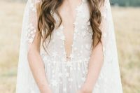 a neutral star applique wedding dress with a plunging neckline and a capelet that matches and accents the outfit even more