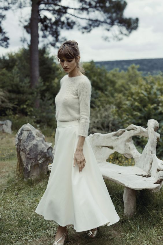 a neutral sweater, a white A-line midi skirt, silver shoes for a pretty and lovely winter bridal look