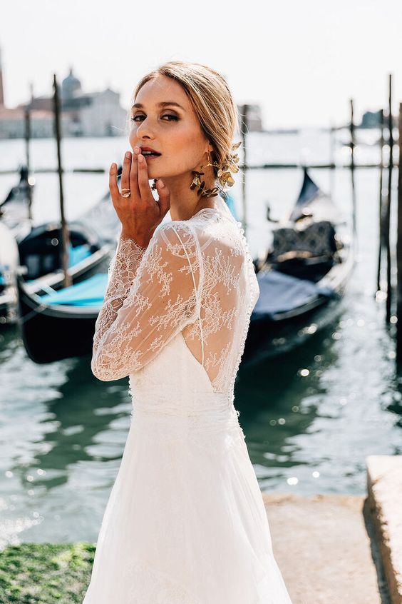 a refined birdal look with a lace wedding dress with an illusion back and statement black and gold flower earrings that wow