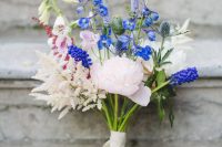 a small and bright wedding bouquet with bold blue, white and blush blooms of various kinds is a cool idea for a boho summer bride