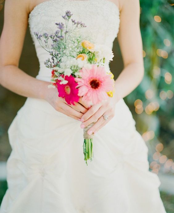 a small and colorful wedding bouquet of pink and hot pink gerberas, greenery, peachy and lilac blooms and a relaxed summer wedding
