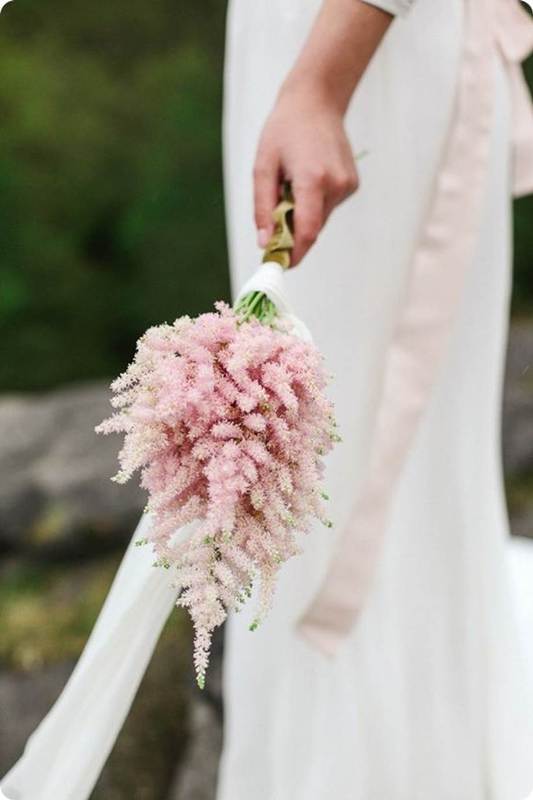 a small pink astilbe wedding bouquet with white ribbons is a lovely idea for a spring or summer minimalist bride