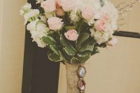 a small vintage wedding bouquet of white and pink garden roses, thistles, eucalyptus, greenery, a burlap wrap with portraits