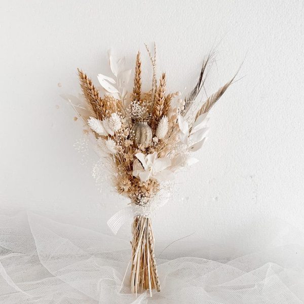 a small wedding bouquet of dried blooms, grass and leaves plus feathers is a very trendy solution for a fashion-forward bride