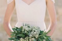 a small wedding bouquet of leaves and thiny white buds is a very delicate and fresh idea for a spring or summer bride