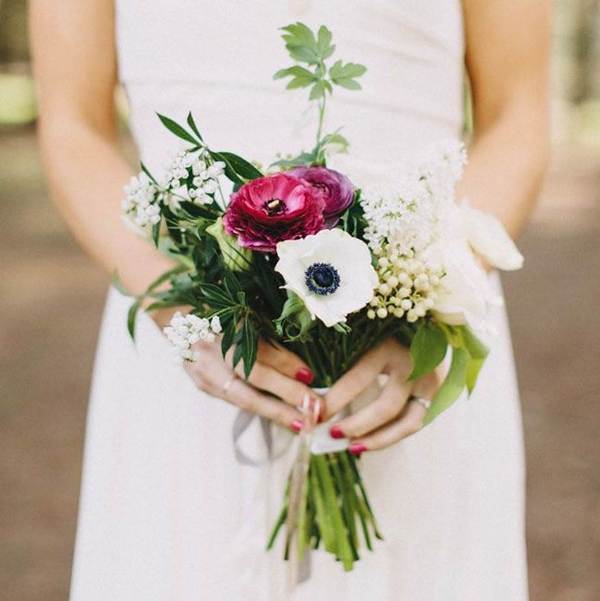 a small wedding bouquet of white and fuchsia blooms and various types of greenery is a whimsy idea for a modern bride