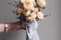 a tiny and lovely white peony wedding bouquet with some eucalyptus and a pretty white ribbon wrap is a gorgeous idea for a spring bride