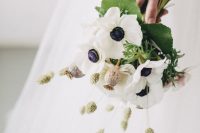 a unique wedding bouquet of white anemones, bunny tails and seed pods and leaves is a catchy idea for a spring wedding