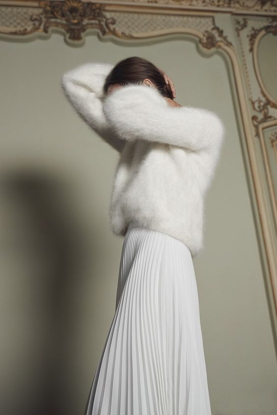 a white oversized fuzzy sweater plus a white pleated maxi skirt for an elegant and timeless casual bridal look
