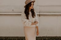 a white sweater, a blush midi slip skirt, neutral shoes and a grey hat for a chic casual bridal look