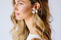 statement white flower earrings with crystals in the center are amazing to rock them at a glam and refined modern wedding