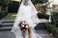 02 a beautiful A-line oversized wedding dress with a high neckline and puff sleeves, black logo shoes, a long fringe veil inspired by the 70s