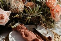 02 a beautiful copper bronze wedding tablescape with lush florals and greenery, a woven placemat and a rust-colored napkin is chic