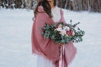 02 a beautiful winter bridal look with a neutral lace embellished wedding dress, a pink cover up, a neutral and pink bouquet with pink ribbons