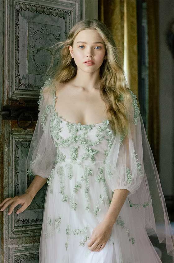 a delicate bridal look with an a-line wedding dress with floral applique detailing, semi sheer short sleeves, a square neckline