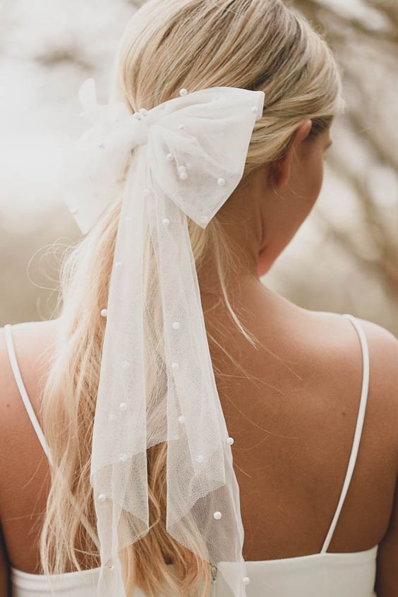 a beautiful tulle and pearl hair bow is a refined and chic solution for a modern and delicate bridal look with a girlish touch