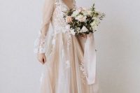 03 a blush A-line wedding dress with a v-neckline, puff sheer sleeves and white floral appliques for a delicate and chic bridal look