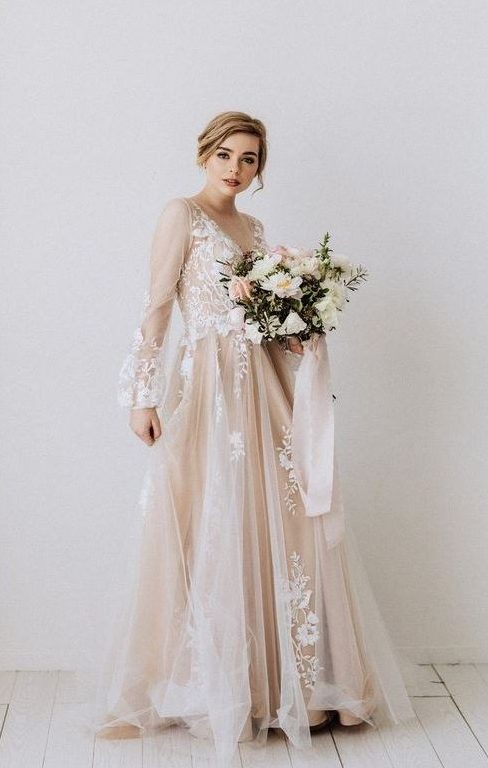 a blush A-line wedding dress with a v-neckline, puff sheer sleeves and white floral appliques for a delicate and chic bridal look