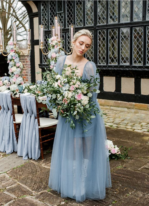 a modern take on Daphnae look - a pastel blue A-line semi sheer wedding dress with a square neckline, puff sleeves and a pleated skirt