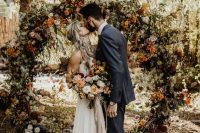 06 a lovely round earthy-tone wedding arch with lush florals and greenery plus twigs is a beautiful idea to rock