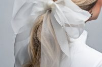 06 a twisted low ponytail accented with a large bow is a very glam and fresh idea for a modern bride