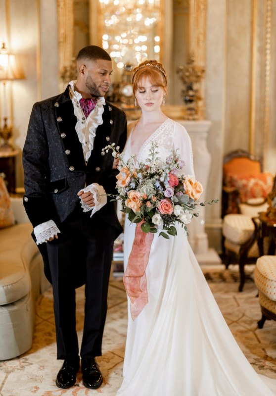 gorgeous themed couple's looks - a glam take on a morning suit for the groom and a beautiful A-line wedding dress with a lace bodice and a train for the bride