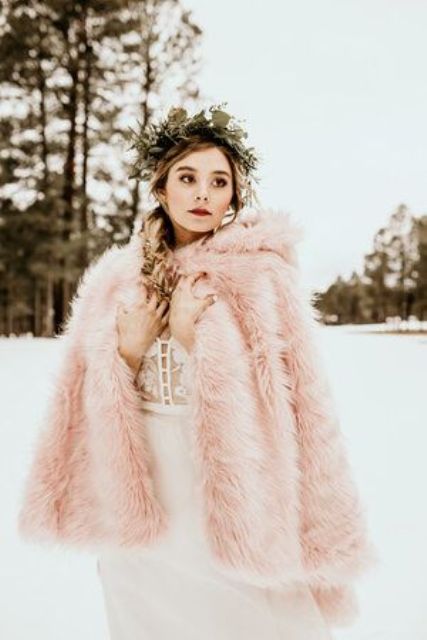 a dreamy winter bridal look with a neutral modern wedding dress and a pink faux fur cover up with a hood is a gorgeous idea