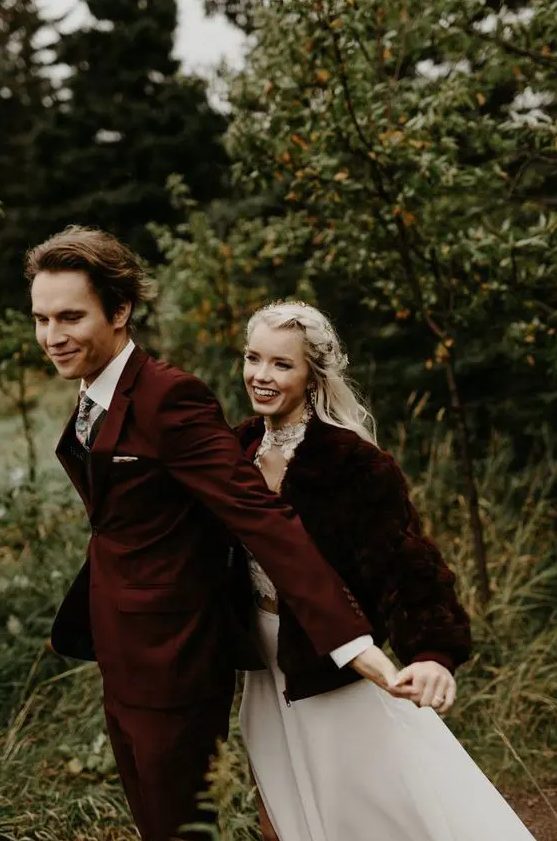 a neutral wedding dress with a high neckline, a burgundy faux fur jacket and an embellished headpiece for a Christmas wedding