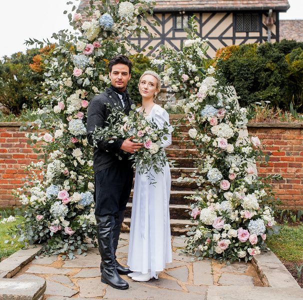 a lush pastel floral wedding altar and the couple dressed in vintage looks - a modenr take on the Duke's look and a delicate vintage-inspired wedding dress plus a tiara