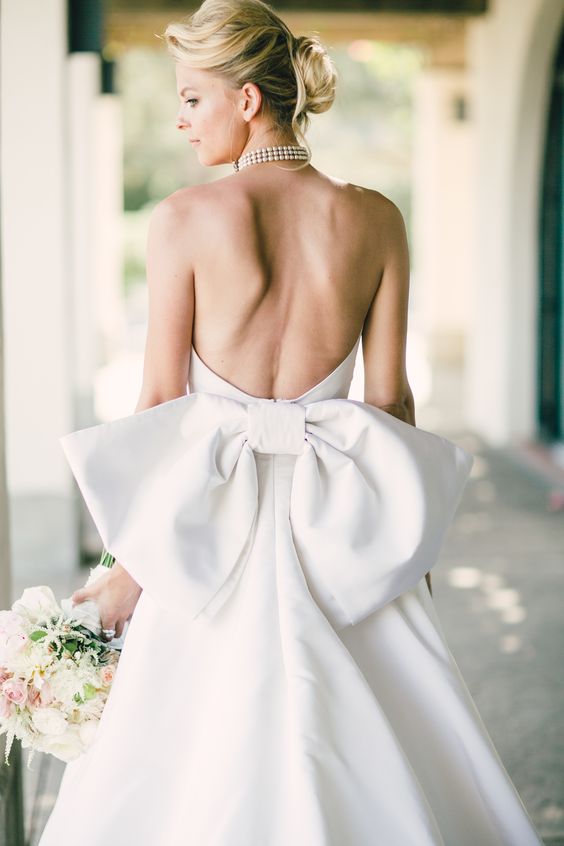 a fantastic wedding ballgown with an open back and an oversized bow to highlight it is a jaw-dropping solution with a royal feel
