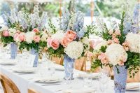 14 a chic and classic wedding tablescape with neutral linens, periwinkle vases with periwinkle, pink and neutral blooms and greenery