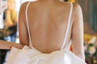 14 a gorgeous fitting wedding dress on straps, with an open back and an oversized bow for a lovely and chic look at your wedding