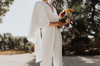15 a chic plain white jumpsuit with a capelet and a deep V-neckline, silver shoes and statement earrings for a bold look