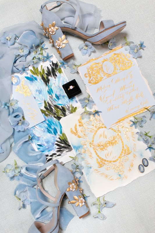 a fantastic wedding stationery with bright watercolor florals and gold detailing is ideal for a blue-colored Bridgerton wedding