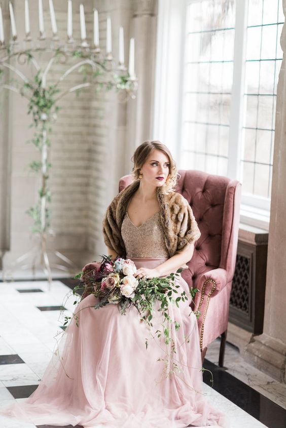 a refined winter bridal look with a sequin bodice with a V-neckline, a pink skirt, a brown faux fur cover up and a bold lip