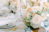 19 a beautiful wedding tablescape with peachy blooms, neutral candles, neutral porcelain, printed menus and candles in blue candleholders