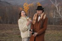 21 a creative boho groom’s look with a rust-colored coat with a fur collar, black trousers, brown shoes and a brown bow tie