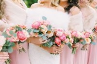 21 bridesmaids wearing pink maxi dresses and matching blush cover ups and holding cool pink and blush peony rose wedding bouquets