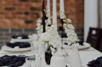 22 a chic modern black and white wedding tablescape with white porcelain, black napkins, black and white vases and matching candles